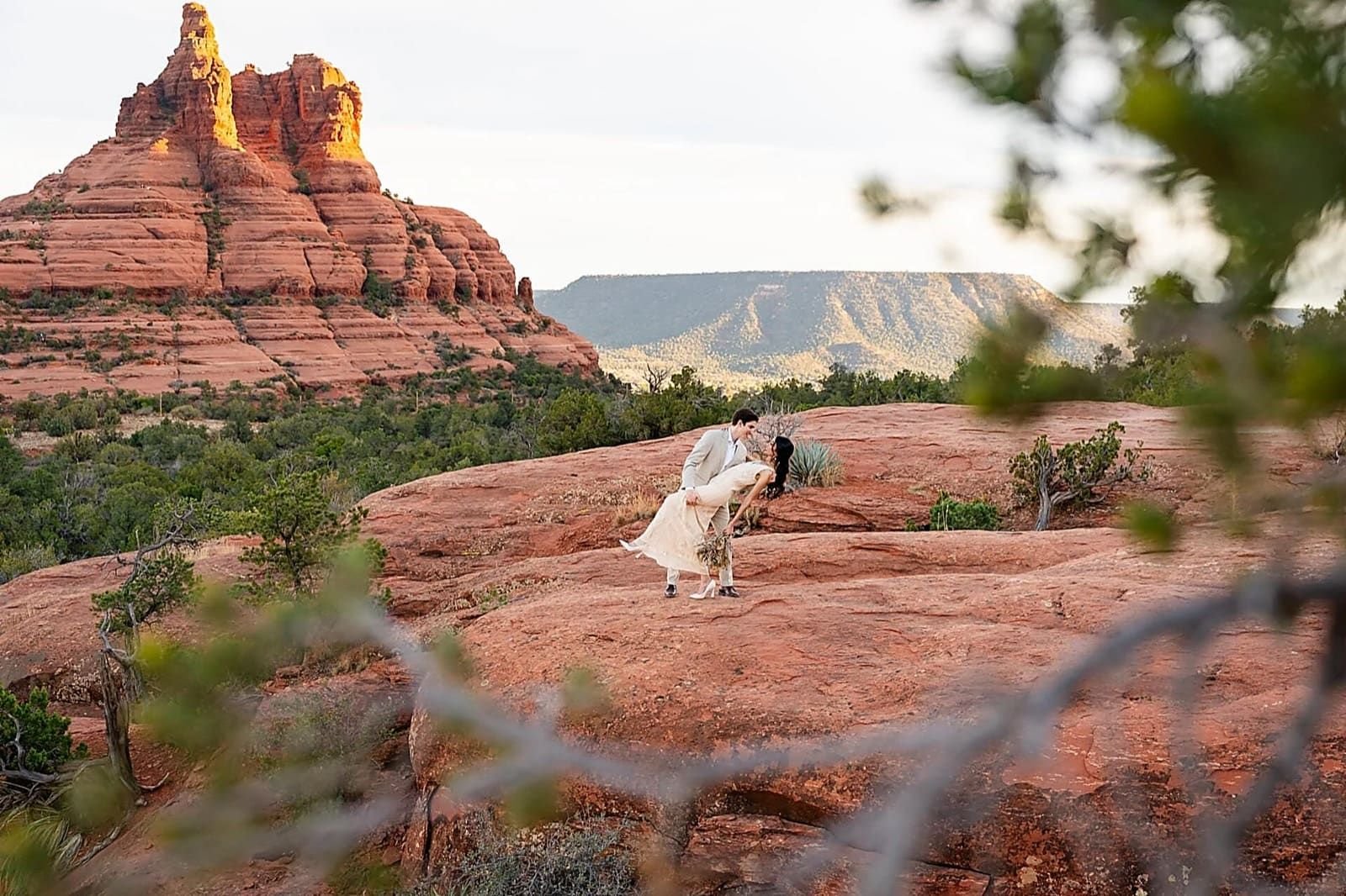 Couple eloping among red rock formations at golden hour — Sedona, AZ